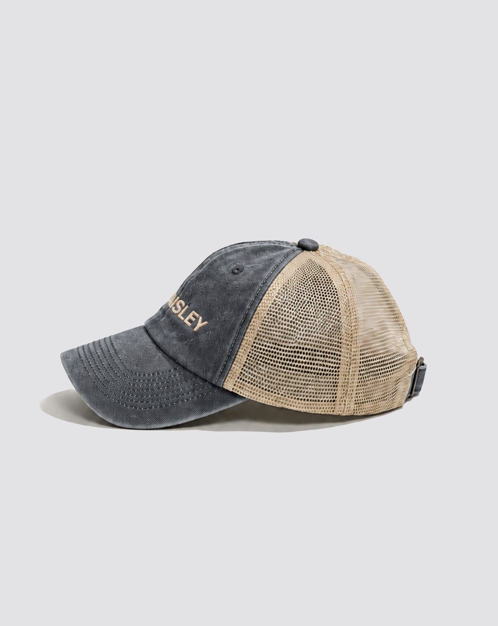 Side view of the Daisley washed slate blue trucker cap with cream mesh panels and a curved brim